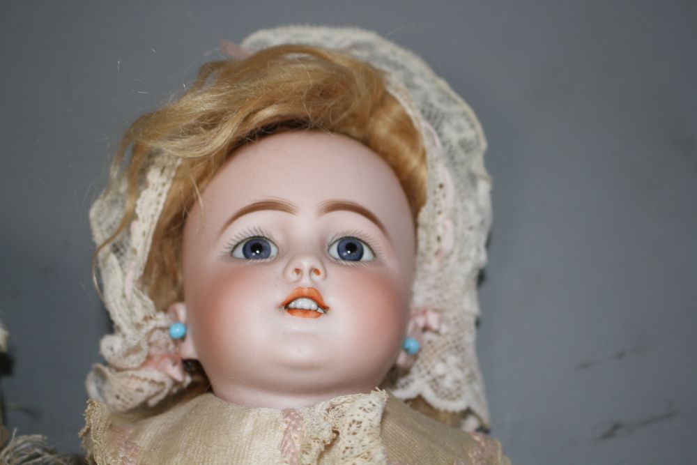 A Simon and Halbig bisque head doll with fixed blue eyes, pierced mouth and pierced ears, no.1250/4½, an unmarked bisque head doll,